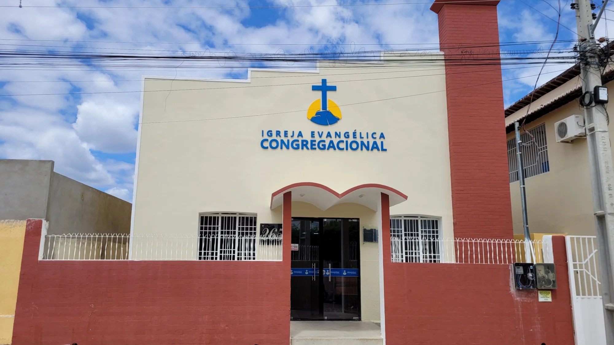 Fachada do templo da Igreja Evangélica Congregacional de Pombal, com o letreiro, a cruz e a entrada em arcos